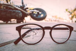 Broken glasses on the road and motorcycle after a crash